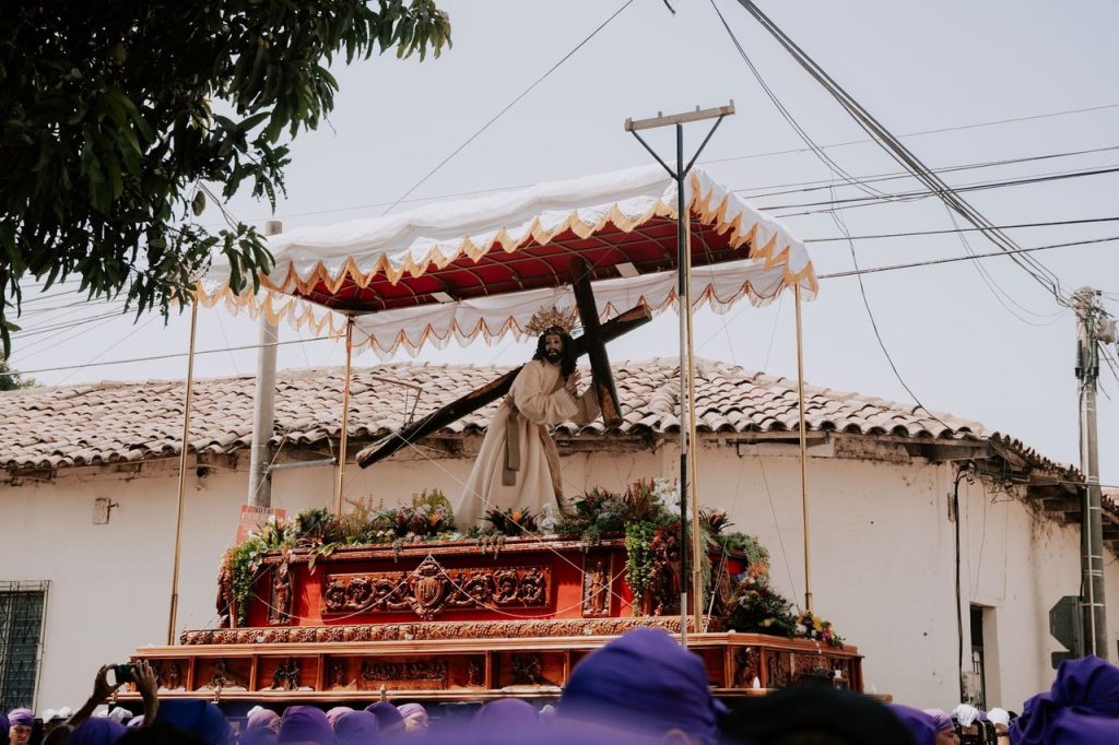 Procissão religiosa com uma estátua de Jesus Cristo carregando a cruz durante a Semana Santa.