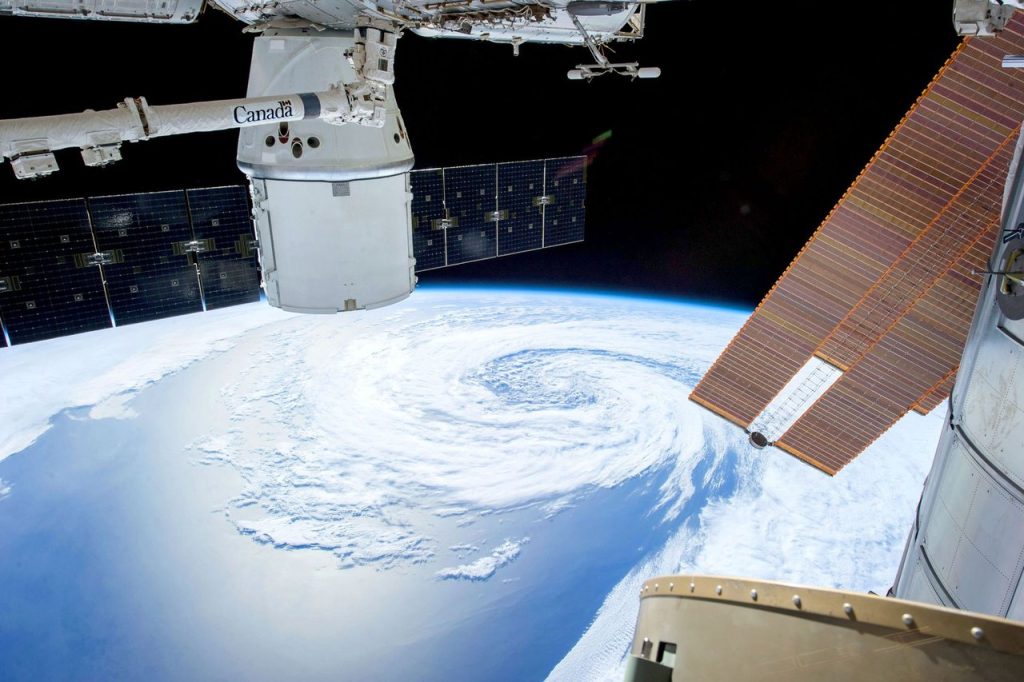 Inovação espacial ganha plano com foco em pesquisa, empresas e formação profissional Vista da Terra a partir do espaço, com painéis solares e módulos de uma estação ou satélite em primeiro plano